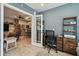 Sunlit office area with a workspace, neutral colored walls, and a view of the kitchen at 14924 Old Dixie Hwy, Hudson, FL 34667