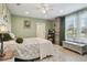 A comfortable bedroom with green walls and accents, neutral colored bedding, and a view of the window at 14924 Old Dixie Hwy, Hudson, FL 34667
