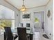 Dining area with a modern glass-top table and direct access to an outdoor deck at 14924 Old Dixie Hwy, Hudson, FL 34667