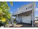 House exterior with a white deck and a view of the guest parking with stairs and palm trees at 14924 Old Dixie Hwy, Hudson, FL 34667