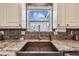 A close up view of the updated kitchen with granite countertops and a copper farmhouse sink at 14924 Old Dixie Hwy, Hudson, FL 34667