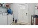 Functional laundry room with white washer and dryer, shelving, and exterior access door at 14924 Old Dixie Hwy, Hudson, FL 34667