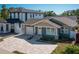 A craftsman-style house featuring a brick driveway, attached garage, front garden, and two-story adjacent building at 1510 49Th N St, St Petersburg, FL 33710