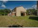 Inviting backyard with green lawn, blue Adirondack chairs on the patio, and privacy fence at 1701 Brigadoon Dr, Clearwater, FL 33759
