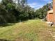 Spacious backyard features a lush green lawn and mature trees, great for outdoor enjoyment at 1701 Brigadoon Dr, Clearwater, FL 33759