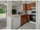Charming kitchen with white appliances and an adjacent living area at 1701 Brigadoon Dr, Clearwater, FL 33759