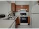 Well-lit kitchen with stainless steel sink and view of adjacent seating area at 1701 Brigadoon Dr, Clearwater, FL 33759