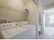 Bright laundry room features a washer, dryer, and wire shelving for storage at 1701 Brigadoon Dr, Clearwater, FL 33759