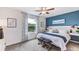 Stylish main bedroom featuring a blue accent wall, a ceiling fan, and bedside tables at 17503 Spainsh Oak Loop, Land O Lakes, FL 34638