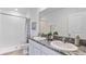 Bathroom featuring double sinks with gray granite countertops, a shower with gray and white tile surround at 17523 Spainsh Oak Loop, Land O Lakes, FL 34638