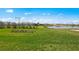 A lush green lawn extends to a serene lake, framed by clear blue skies at 1895 Ridgemore St, North Port, FL 34289