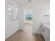 Bright bathroom with wood-look tile flooring and a view of the bedroom beyond at 1895 Ridgemore St, North Port, FL 34289