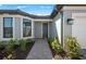 Inviting home entrance with a stone pathway, manicured landscaping, and stylish exterior lighting at 1895 Ridgemore St, North Port, FL 34289