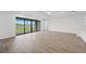 Bright living room with wood-look tile flooring, large windows, and a view of the lake at 1895 Ridgemore St, North Port, FL 34289