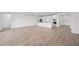 Bright, open-concept living room features wood-look tile flooring and a modern, all-white kitchen at 1895 Ridgemore St, North Port, FL 34289