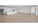 Bright, open-concept living room features wood-look tile flooring and a modern, all-white kitchen at 1895 Ridgemore St, North Port, FL 34289