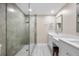 Modern bathroom featuring a glass-enclosed shower and double vanity with white cabinets and marble countertops at 19029 Us Highway 19 N # 21E, Clearwater, FL 33764