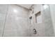 Elegant walk-in shower with stylish tile, recessed shelves, and glass door at 19029 Us Highway 19 N # 21E, Clearwater, FL 33764