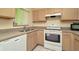 Bright kitchen features light wood cabinets, white appliances and tiled floor at 2263 Fluorshire Dr, Brandon, FL 33511
