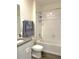 Bright bathroom featuring a shower-over-tub and vanity with gray countertop and wooden floors at 31888 Treasure Dock Isle, Wesley Chapel, FL 33545