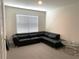 Cozy bedroom featuring a comfortable black couch for relaxation and a bright window at 31888 Treasure Dock Isle, Wesley Chapel, FL 33545