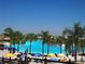 Beautiful community pool with palm trees, sandy beach, umbrellas, and lounge chairs providing a resort-style experience at 31888 Treasure Dock Isle, Wesley Chapel, FL 33545