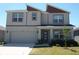 Charming two-story home with a front yard, attached garage and covered front porch at 31888 Treasure Dock Isle, Wesley Chapel, FL 33545