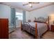 Bedroom features a window, ceiling fan, wood-look floors, and soft blue curtains at 322 Club Manor Dr, Sun City Center, FL 33573