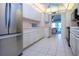 Bright kitchen featuring a stainless steel refrigerator, white cabinets and open access to the living area at 322 Club Manor Dr, Sun City Center, FL 33573