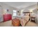 Charming bedroom featuring patterned bed, red dresser, woven trunk, and warm lamps creating a cozy atmosphere at 4766 Snook Se Dr, St Petersburg, FL 33705