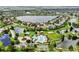 Aerial view featuring a community pool, surrounding homes, and a large lake, all enhanced by lush landscaping at 5324 Moon Shell Dr, Apollo Beach, FL 33572