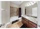 Full bathroom features granite counters, decorative tile, modern fixtures, and a shower-tub combination with shower curtain at 5324 Moon Shell Dr, Apollo Beach, FL 33572