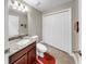 Bathroom featuring granite counters, dark cabinets, and a toilet with tiled floor, white door and a big mirror at 5324 Moon Shell Dr, Apollo Beach, FL 33572