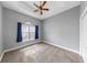Empty bedroom with gray walls, carpeted flooring, a ceiling fan, and a window with blue curtains at 5324 Moon Shell Dr, Apollo Beach, FL 33572