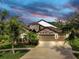 Attractive home featuring stone details, a three-car garage, and mature landscaping at 5324 Moon Shell Dr, Apollo Beach, FL 33572