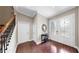 Grand foyer featuring decorative glass double doors, sleek wood flooring, and staircase with dark iron details at 5324 Moon Shell Dr, Apollo Beach, FL 33572