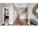 Bright hallway featuring wood floors, archways, and a staircase with wrought iron spindles at 5324 Moon Shell Dr, Apollo Beach, FL 33572