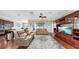 Spacious living room features wood floors, ceiling fan and a large TV on the far wall at 5324 Moon Shell Dr, Apollo Beach, FL 33572