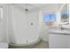Clean bathroom features a shower with white curtain, vanity with marble countertop and a window at 540 59Th Ave, St Pete Beach, FL 33706