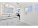 Bright bathroom featuring a vanity with marble countertop, an illuminated mirror, and modern fixtures at 540 59Th Ave, St Pete Beach, FL 33706