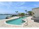 Inviting waterfront pool area with a boat dock, palm trees, and clear blue skies at 540 59Th Ave, St Pete Beach, FL 33706