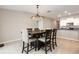 Dining area features tile flooring, a stylish chandelier, and views into the kitchen at 5412 Blue Azure Dr, Wimauma, FL 33598