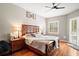 Main bedroom with a wooden bed frame, shuttered windows, and hardwood floors at 5627 Glencrest Blvd, Tampa, FL 33625