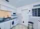 Cozy kitchen featuring white cabinets, appliances, patterned tile walls, and a window at 619 41St Ne Ave, St Petersburg, FL 33703