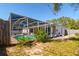 A screened pool area with clear blue water, adjacent to a well-maintained backyard at 627 Kenneth Way, Tarpon Springs, FL 34689