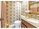 Compact bathroom features floral wallpaper, granite counters and wood vanity at 7016 2Nd N St, St Petersburg, FL 33702