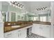 Modern bathroom featuring double sinks with granite countertops and stylish vanity lighting at 7116 Colonial Lake Dr, Riverview, FL 33578