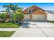 Charming two-story home with a three-car garage, lush landscaping, and a well-maintained driveway at 7116 Colonial Lake Dr, Riverview, FL 33578