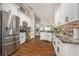 Modern kitchen featuring white cabinets, stainless steel appliances, wood floors, and granite countertops at 7116 Colonial Lake Dr, Riverview, FL 33578