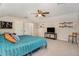 Spacious main bedroom features a ceiling fan, tv, shelving and a comfortable king-size bed at 7116 Colonial Lake Dr, Riverview, FL 33578